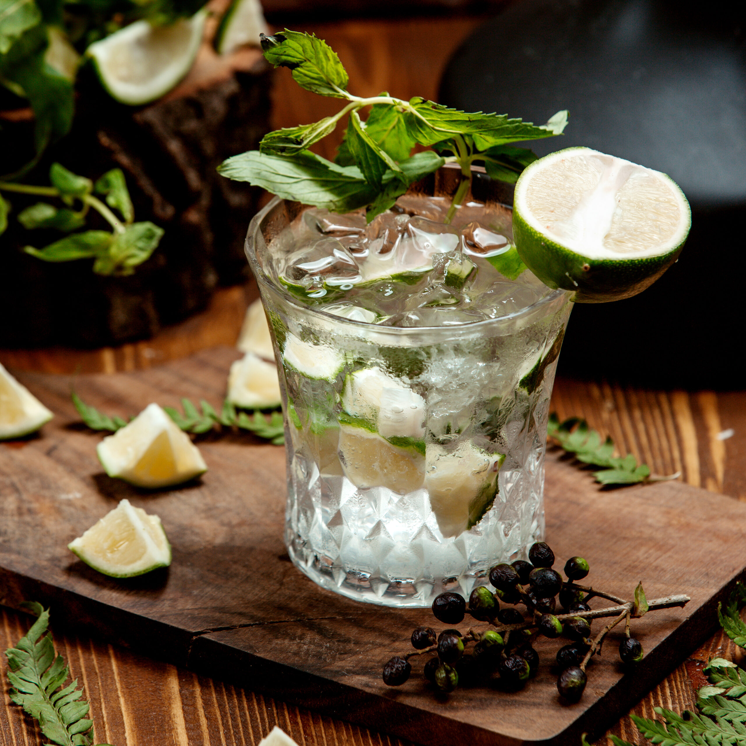 a crystal glass of mojito drink garnished with lime slices